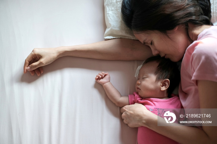 Close up beautiful portrait from top view of beautiful young Asian mother kissing her newborn baby s