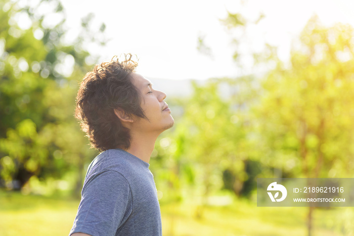 Happy Asian man breathing deeply in outdoor