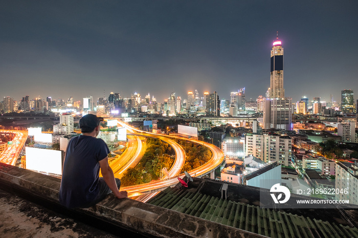 Men are sitting on balcony with sightseeing the city glowing at night