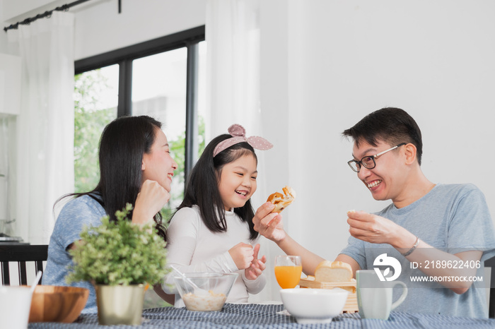 Asian family happy enjoy having breakfast on table in kitchen