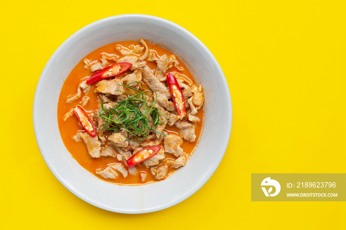 Panaeng Curry with pork  in white bowl on yellow background.