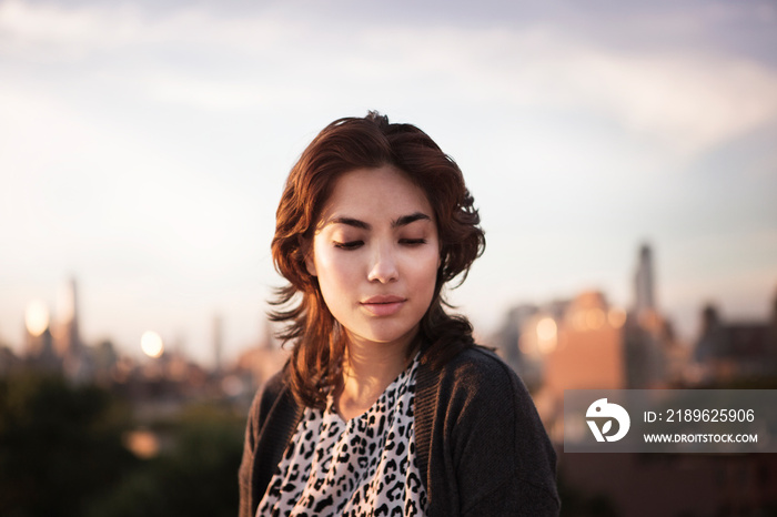 Portrait of young woman with skyline in background