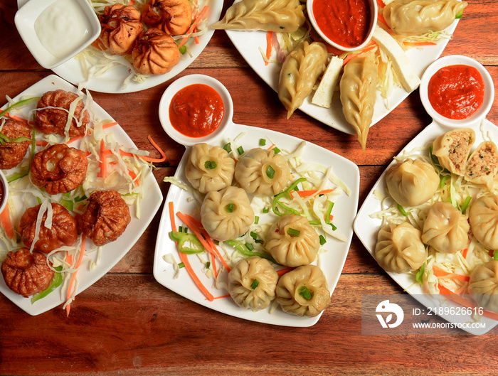 Variety of Nepalese traditional dumpling momos served with tomato ketchup and fresh salad.