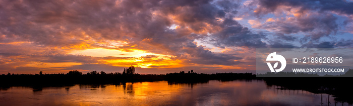 Panorama Reflection of vivid sunset sky reflection in  water.Colorful sunrise with Clouds over Lake 