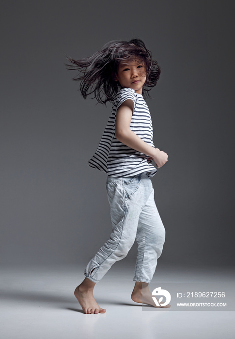 Happy Asian little girl playing in the studio