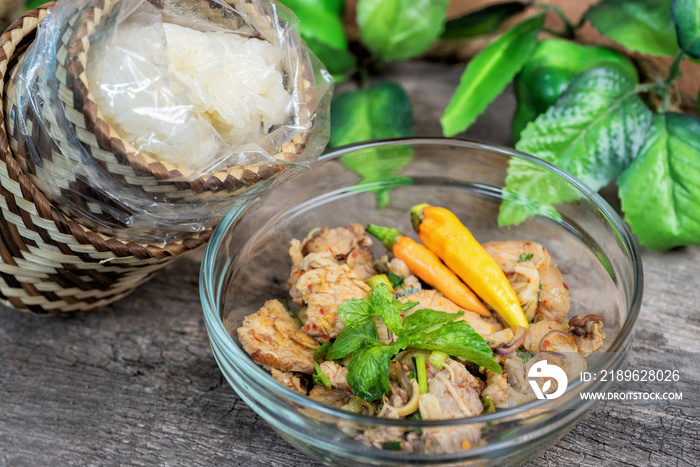 Spicy Minced Pork Salad and Thai sticky rice in a bamboo wooden old style box.Thai food style.