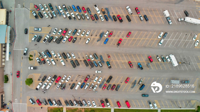 Aerial view of cars at large outdoor parking lots, USA. Outlet mall parking congestion and crowded p