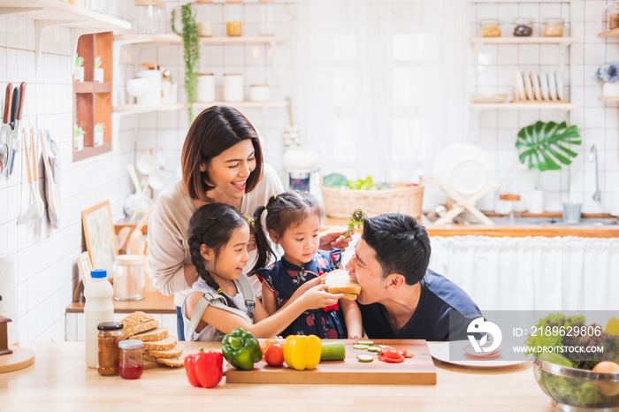 Asian family enjoy playing and cooking food in kitchen at home