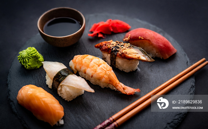 漂亮的日本寿司生鱼片，配虾、姜和酱油，用筷子和g食用