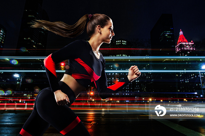 Fitness and sport motivation. Strong athletic woman sprinter, running in the night city. Girl model 