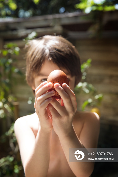 Close-up of boy (4-5) holding egg