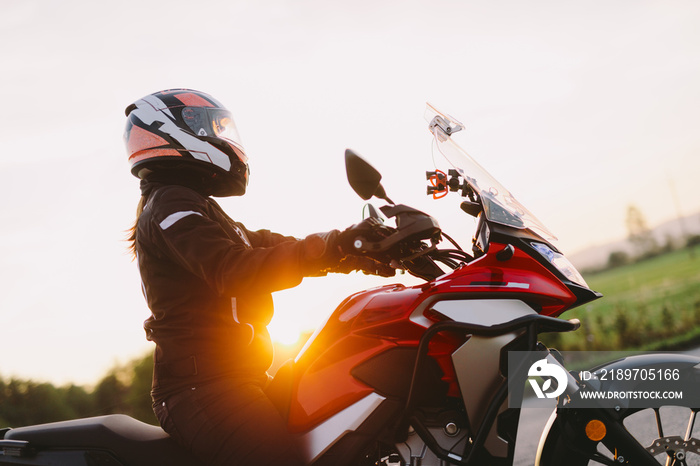 Woman riding motobike at sunset