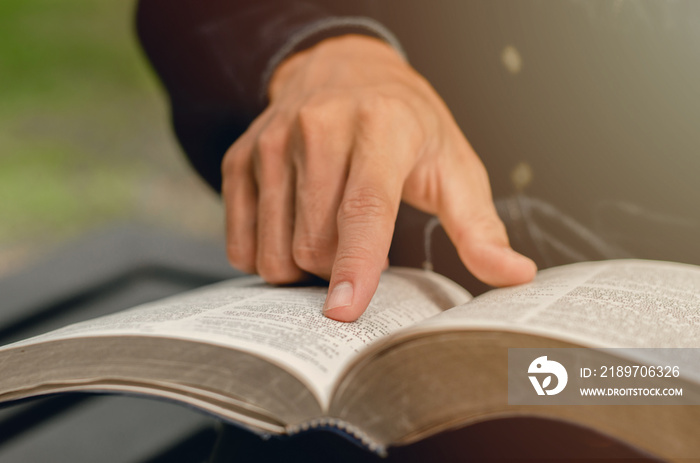 一个年轻人指着圣经的话题，在星期天读圣经，接受上帝的祝福。