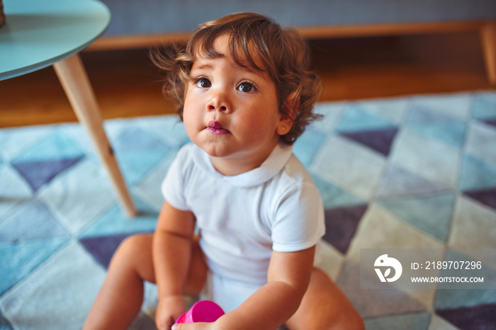 Beautiful toddler child girl wearing white t-shirt playing on the carpet