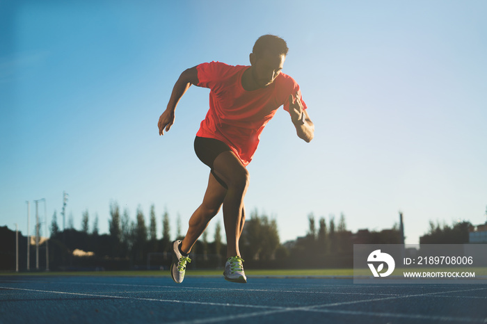 Young athlete man starting to run in a start position in a race. Start stride