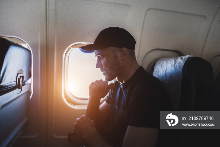 一名压力重重的男子坐在飞机舷窗附近