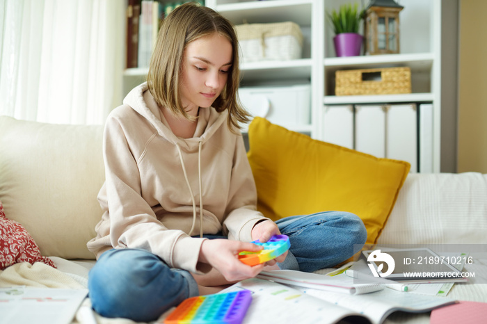 十几岁的女孩在家学习时玩彩虹汽水，坐立不安。十几岁的孩子穿着时髦的str