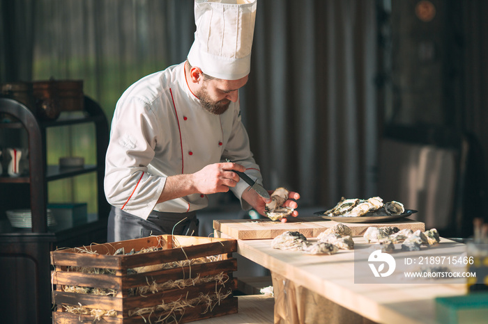 Opening the hollow and flat oysters. Chef opens oysters in the restaurant.