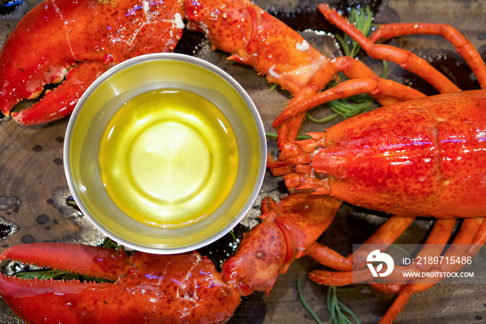 The whole lobster steamed, served with drawn butter on wooden plate. Close up