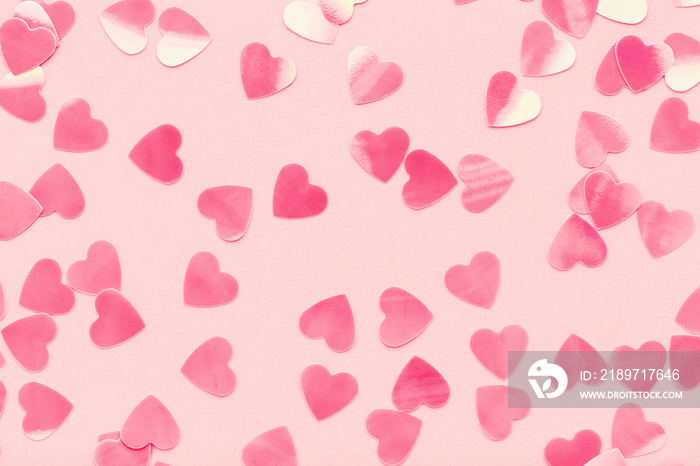 Heart shape confetti on pink pastel holiday background. Festive abstract backdrop, Valentines Day, 