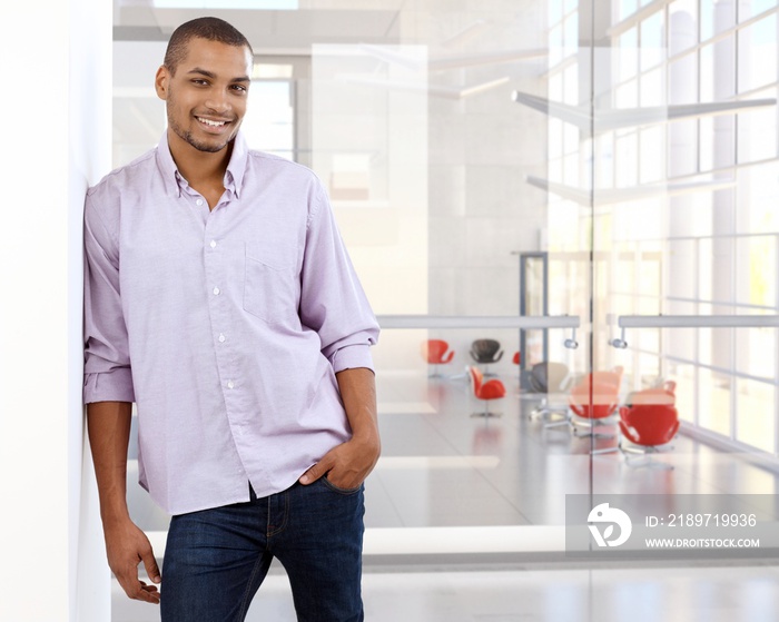 Casual black office worker leaning against wall