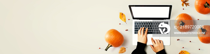 Autumn pumpkins with person using a laptop computer from above