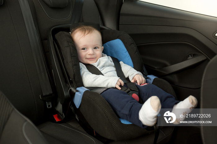 Cute smiling baby sitting in car seat