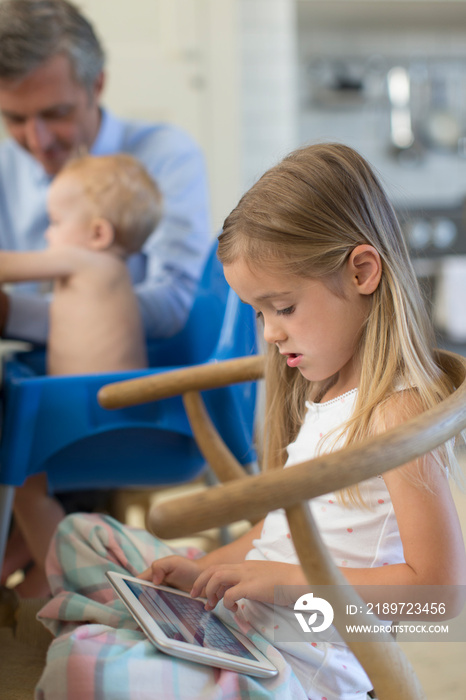 Girl using digital tablet in chair