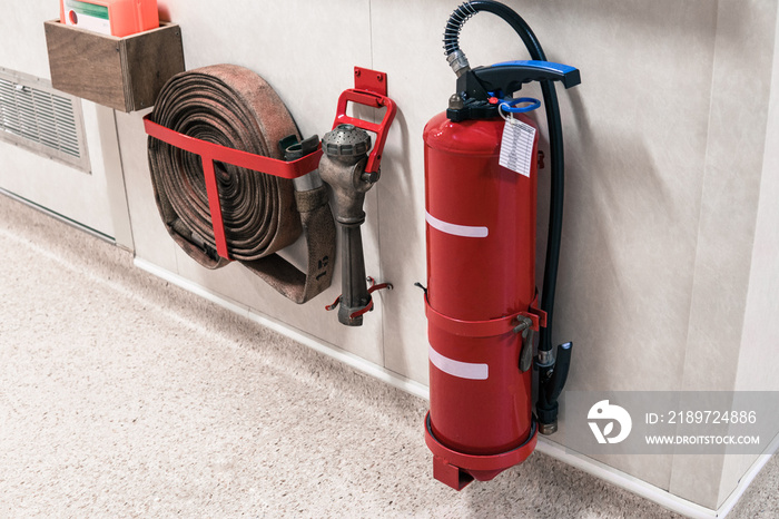 Fire extinguisher and fire hose reel in corridor.