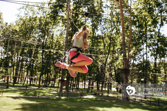 Little brave girl on zipline in rope park