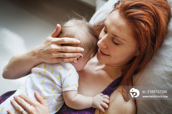 Close up of mother embracing baby girl at home