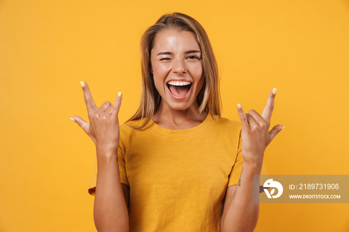 Image of excited woman winking and making horn gesture with fingers