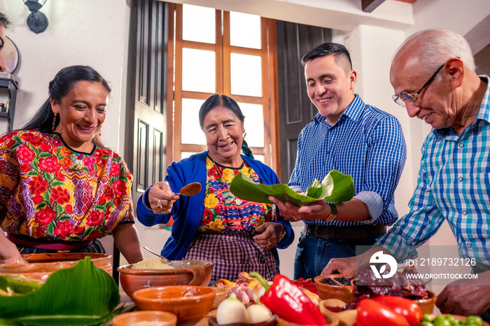 Abuela  enseñando a su nieto a cocinar.  Familia latina cocinando juntos.