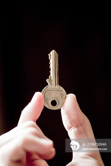 key in hand on dark background