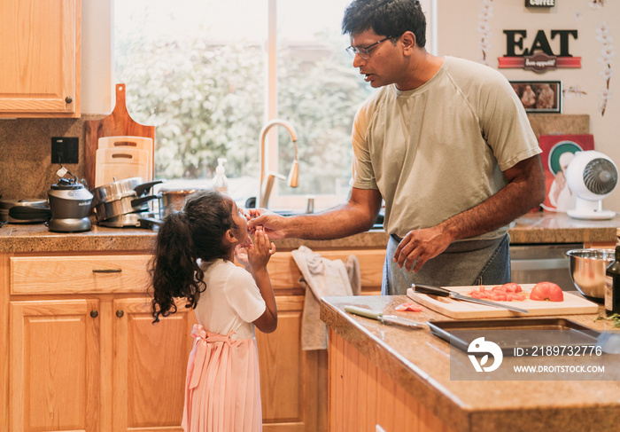 Father feeding his daughter