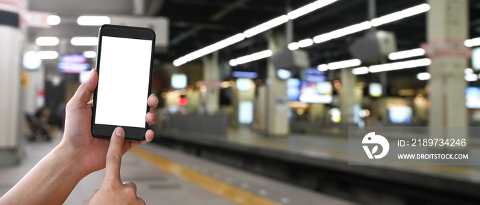 Cropped image of hands is using a white blank screen smartphone at the subway.