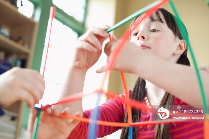 Elementary students using plastic building set