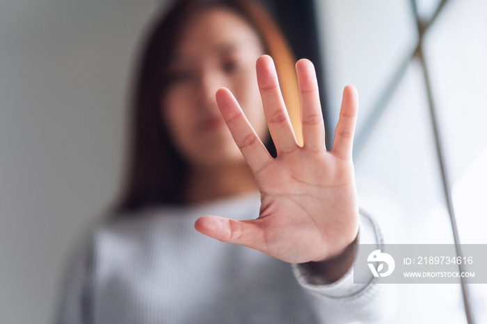 一名妇女伸出手并显示停止手势的特写图像