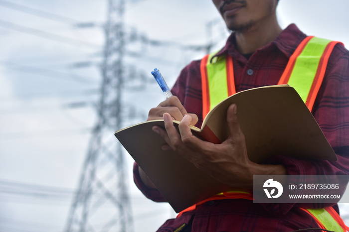 工程师在笔记本上记录工作计划，并为职业提供建筑工人安全帽顾问