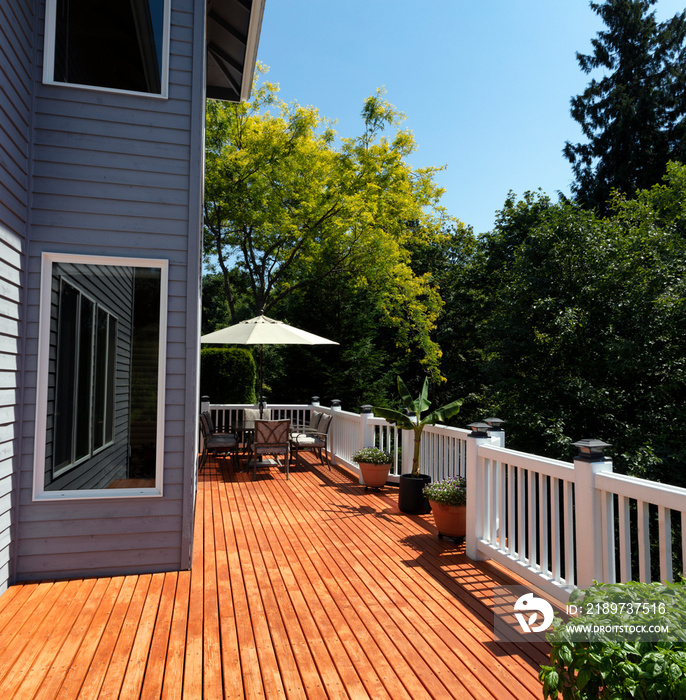 在美丽的夏日，户外家庭木质甲板，带季节性花园