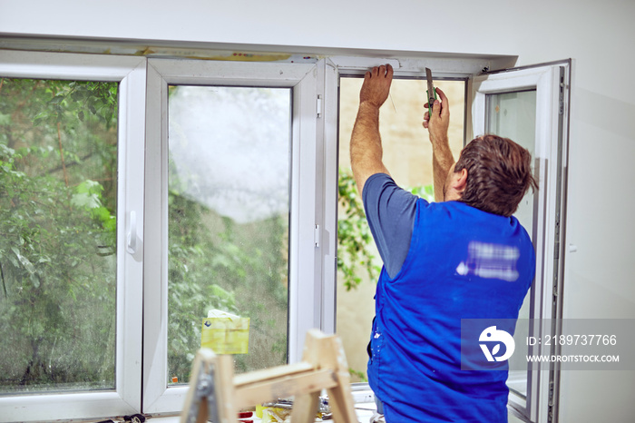 Worker using silicone for walls and widnows inside the house - r