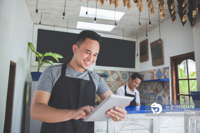 young male cafe owner with tablet