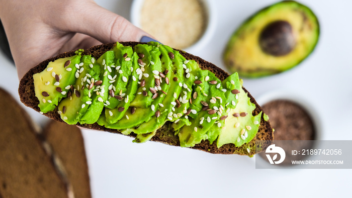 Ingredients for healthy avocado toast. ripe hass avocado, wholegrain bread, sesame flax seeds. Vegan