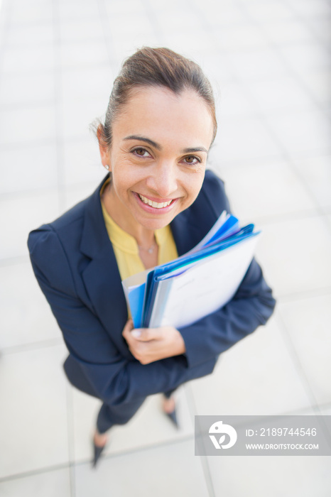 Portrait confident businesswoman with paperwork