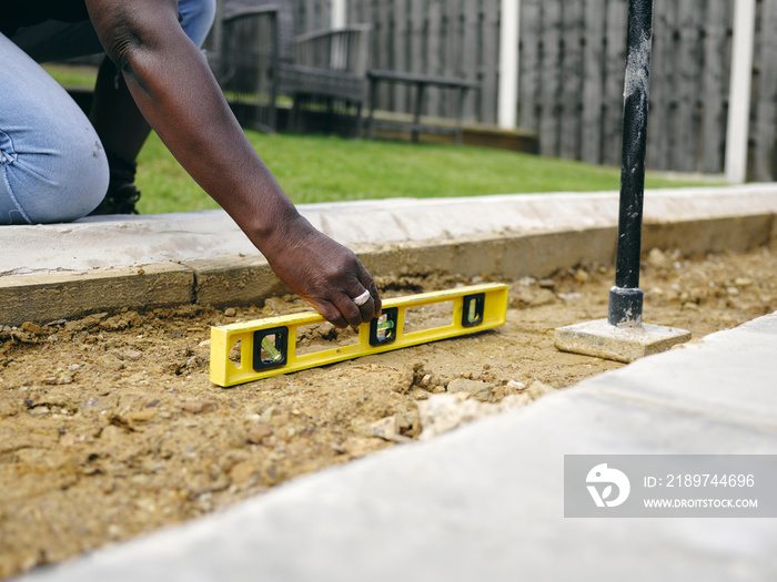 Woman doing construction work in backyard