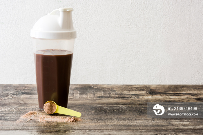 Chocolate protein shake on wooden table. Copyspace