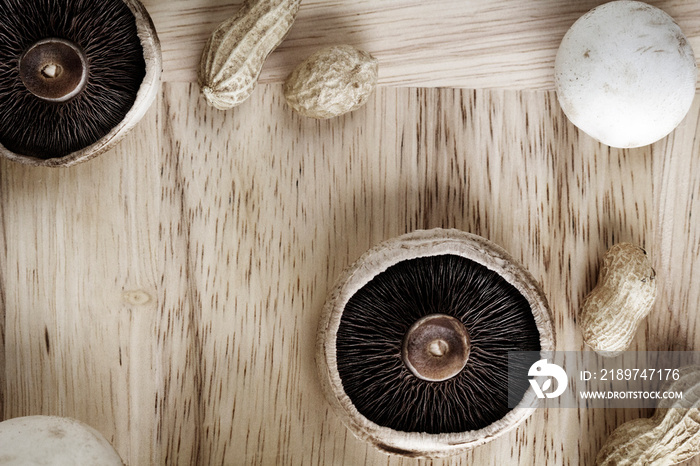 Overhead view of mushrooms and peanuts on cutting board