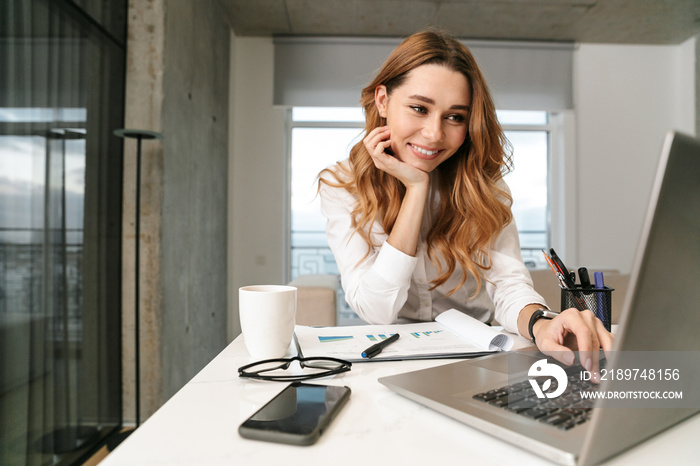 Business woman dressed in formal clothes shirt indoors using laptop computer.