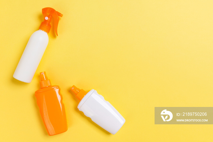 flat lay concept of summer travel vacation. Sunscreen bottle mock up on yellow background top view w