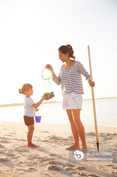 Mother and daughter (2-3) on beach